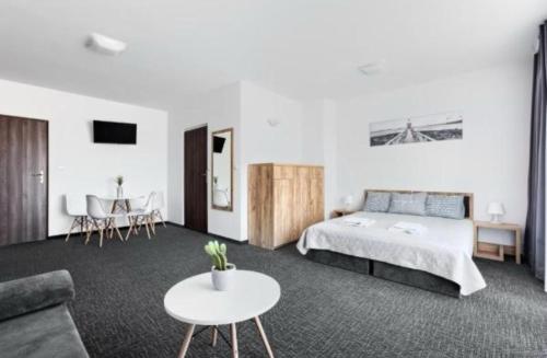 a bedroom with a bed and a couch and a table at Holiday Home Resort & Spa in Jarosławiec