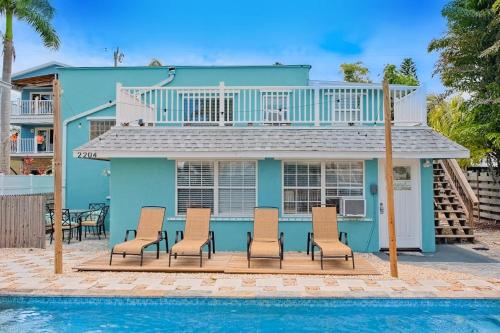 a blue house with chairs and a swimming pool at Bungalow W in Bradenton Beach