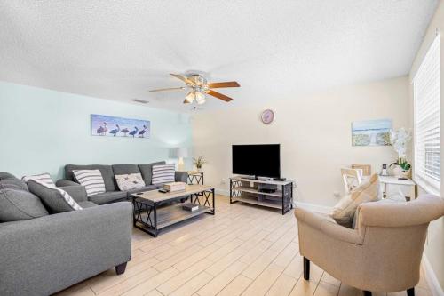 a living room with a couch and a tv at Holmes Beach Bungalow - A in Holmes Beach