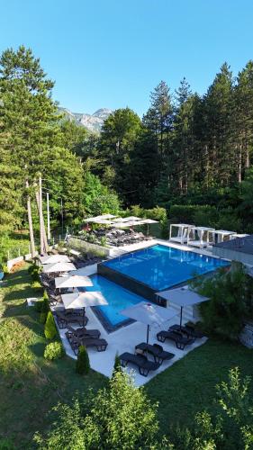 a large swimming pool with chairs and umbrellas at Vila Sunce Village Resort Konjic in Konjic