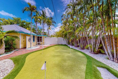 a golf course in front of a house with palm trees at The Wee Cottage in Anna Maria