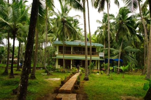 a house in the middle of a forest of palm trees at KK Heritage in Kannur