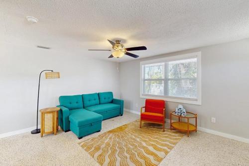 a living room with a blue couch and two chairs at Pineapple House in Holmes Beach
