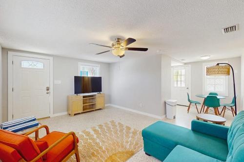 a living room with a blue couch and a tv at Pineapple House in Holmes Beach