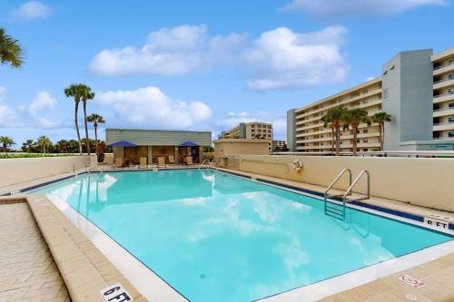 a swimming pool at a resort with buildings and palm trees at The Aquarium in Sarasota