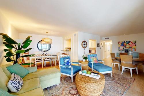 a living room with blue chairs and a dining room at Gulf Place 20 in Holmes Beach