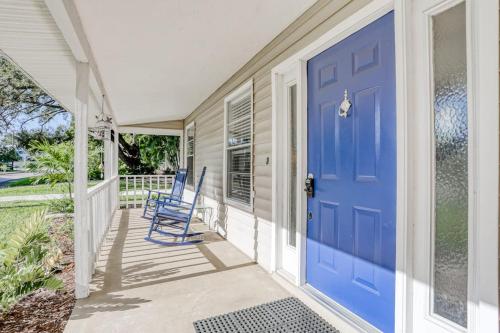a porch with blue chairs and a blue door at Manatee River House in Bradenton