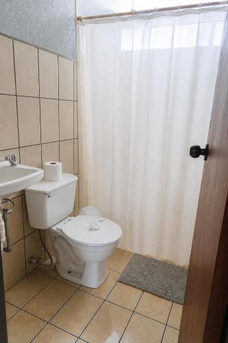 a bathroom with a toilet and a sink and a shower at Arenal Rental CASA PALMERA UNO in Arenal
