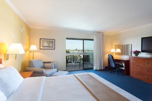 a hotel room with a bed and a desk at The Marina Inn on San Francisco Bay in San Leandro