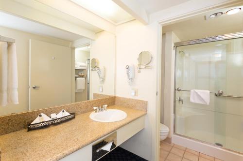 a bathroom with a sink and a shower at The Marina Inn on San Francisco Bay in San Leandro