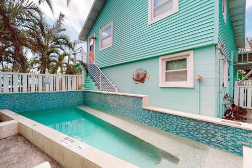 a blue house with a swimming pool in front of it at Nautical Nook at Bayview Inn in Bradenton Beach