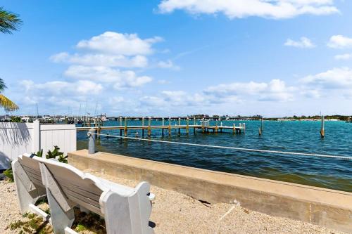 a bench sitting next to the water with a pier at Nautical Nook at Bayview Inn in Bradenton Beach
