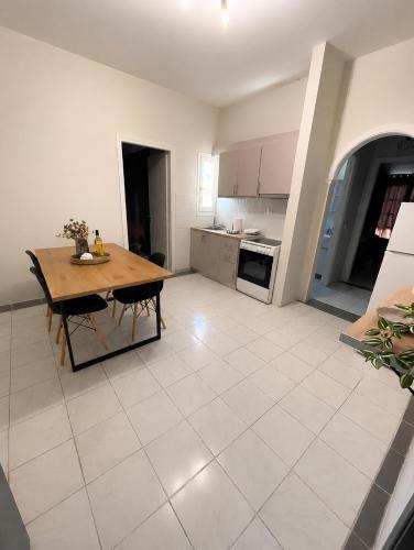 a kitchen with a wooden table and a kitchen with white tiles at Sidari Centre Apartments in Sidari