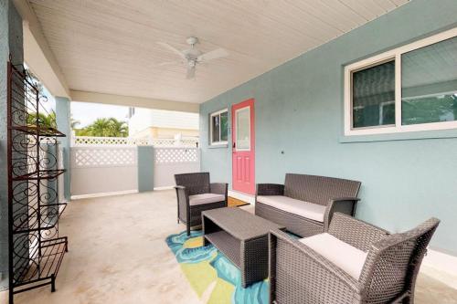 a screened porch with chairs and a red door at South Bay Inn 3 in Anna Maria