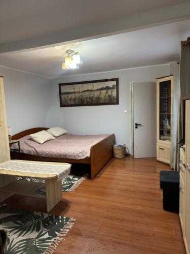 a bedroom with a bed and a wooden floor at Domek M5 w centrum Wiela in Wiele