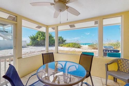 a dining room with a glass table and chairs at Playa Casanas South in Holmes Beach