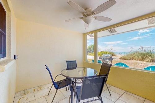 a dining room with a table and chairs and a window at Playa Casanas North in Holmes Beach