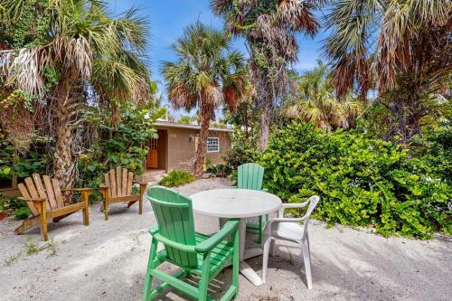 a table and chairs sitting in a yard with palm trees at 21 Palms on Anna Maria in Anna Maria