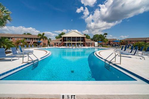 a large swimming pool with blue water and chairs at Carlton Arms View B1 # A in Bradenton