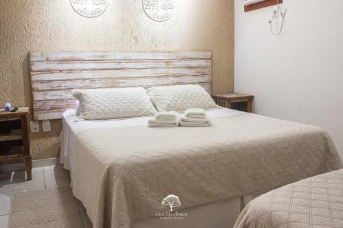 a bedroom with a bed with two towels on it at GuestHouse Casa da Aroeira in Búzios