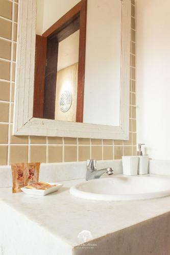a bathroom with a sink and a mirror at GuestHouse Casa da Aroeira in Búzios