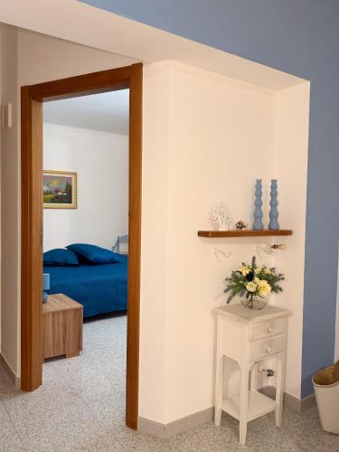 a bedroom with a blue bed and a table with flowers at Dimora Caratin' in Mattinata