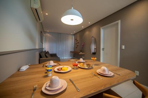 a dining room table with plates of food on it at Wave Suítes Hotel & Lounge bar in Maceió