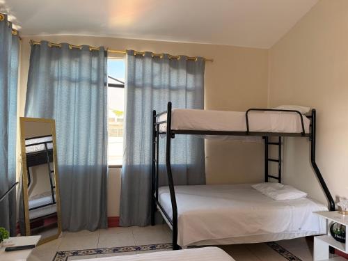 a bedroom with two bunk beds and a window at Habitación Mantarraya in Manta