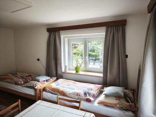 two beds in a room with a window at Guest House Hartenberg in Sokolov