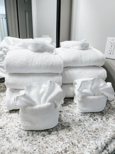a pile of white towels sitting on a bathroom floor at Meadow Room at The Trailblazer Unit 12 in Townsend