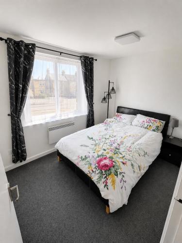 a bedroom with a bed with a floral bedspread at Beautiful Double room in Peterborough