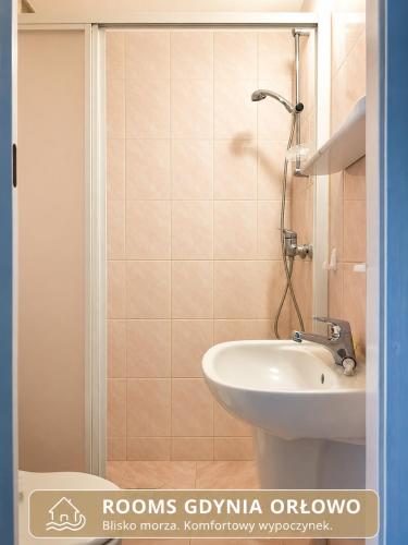 a bathroom with a white sink and a shower at Rooms Gdynia Orłowo in Gdynia