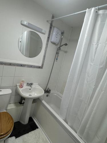 a white bathroom with a sink and a shower at Beautiful Double room in Peterborough