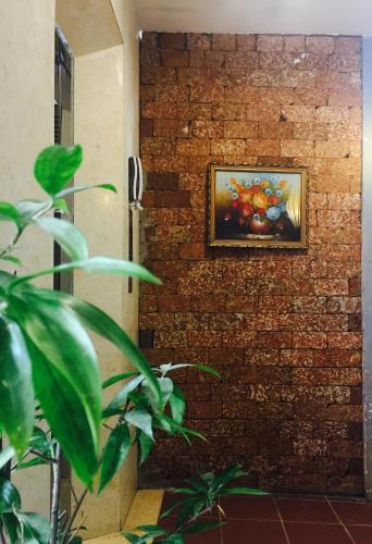 a brick wall with a painting on it at Quan Quan Hotel in Da Nang