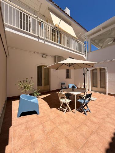 a patio with a table and chairs and an umbrella at Dimora Caratin' in Mattinata