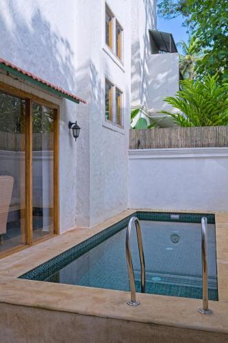 a swimming pool in the backyard of a house at Villa Eden 3BHK in Assagao