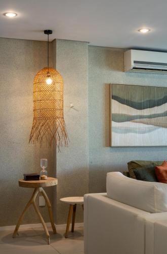 a living room with a couch and a table at Wave Suítes Hotel & Lounge bar in Maceió