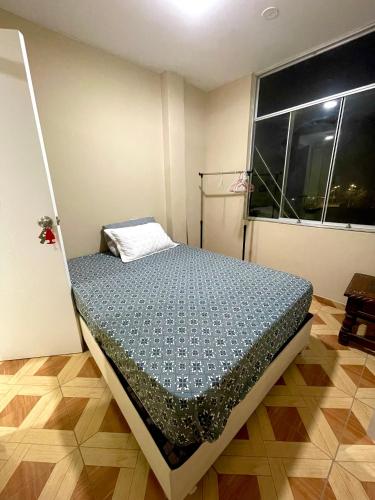 a bed in a room with a window at La casa de Ferro in Piura
