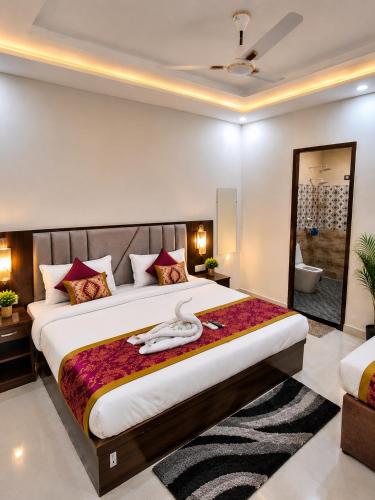 a bedroom with a large bed and a bathroom at Premium Radhe Dham Hotel & Restaurant - Fully AC - Only 5 Min Drive to Prem Mandir, Newly Build in Vrindāvan
