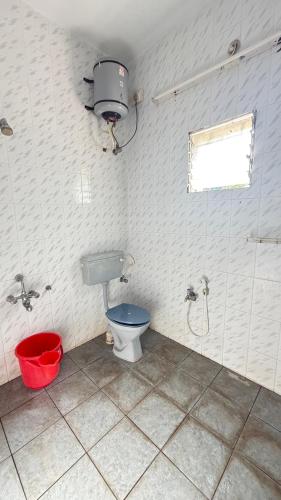 a bathroom with a toilet and a window and a bucket at Gravity Groups Core - Pannai veedu in Puducherry Airpoert