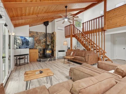 a living room with a couch and a staircase at Hodges Hill Hideout w/ pool, spa, BBQ - Dog Friendly in Oakhurst