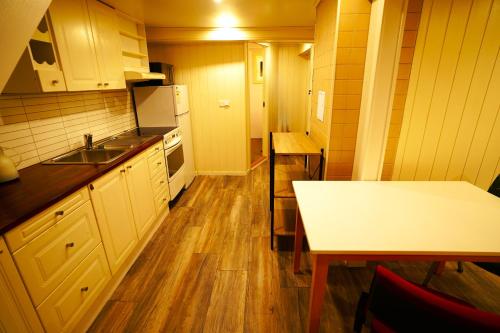 a kitchen with white cabinets and a wooden floor at Comfort Apartment in Tromsø