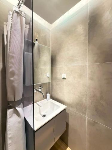 a bathroom with a sink and a shower at Vellora Central Suite in Xanthi