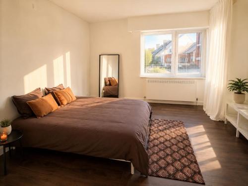 a bedroom with a large bed and a window at Modern 2 BR apartment in Centre in Sint-Niklaas