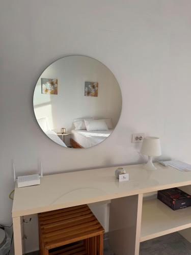 Ein Spiegel über einem Schreibtisch neben einem Bett in einem Zimmer in der Unterkunft Solemare in Himarë