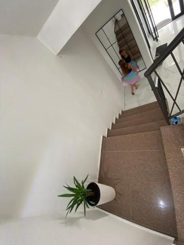 a woman walking down a stairs with a plant at Cozy Apartments in Ulcinj
