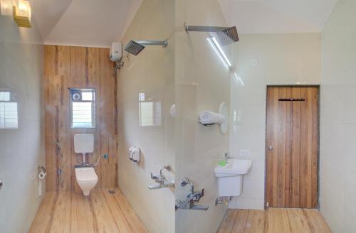 a bathroom with two toilets and a sink and a shower at TAJ VILLA Mahabaleshwar in Mahabaleshwar