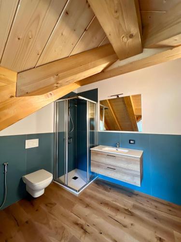 a bathroom with a toilet and a sink and wooden ceilings at Piazza Maggiore Charming Apartament in Santa Maria Maggiore