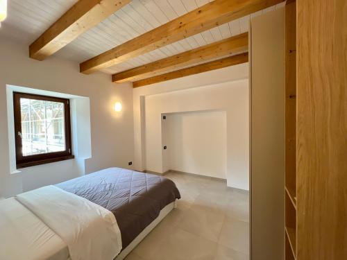 a bedroom with a bed and a window and a door at Piazza Maggiore Charming Apartament in Santa Maria Maggiore