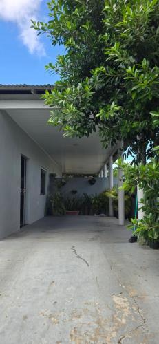 an empty courtyard of a white building with a tree at Mecejana Home in Boa Vista